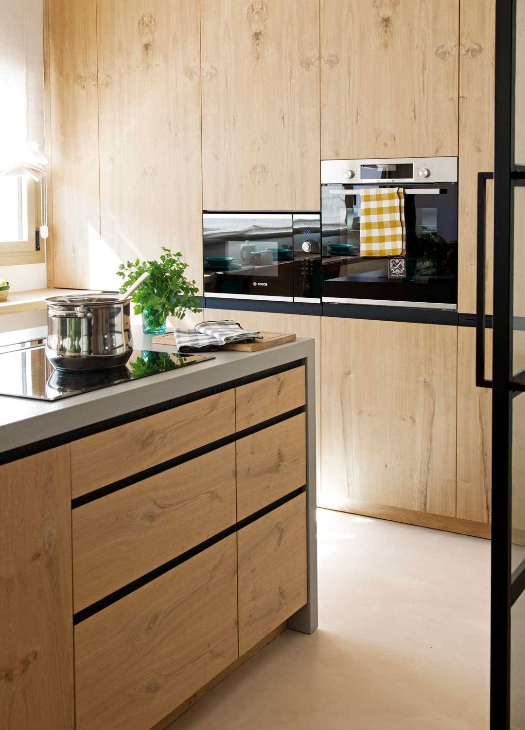 Cocina moderna de madera con gola en negro.